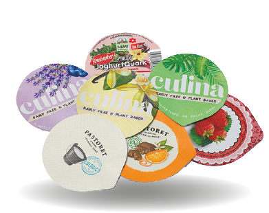 Sieben bunte Joghurtbecher-Deckel mit verschiedenen fruchtigen und floralen Motiven, fächerförmig angeordnet.